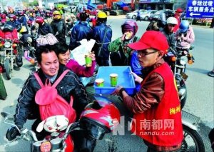 广东梅州警车护送摩托返乡者 志愿者送姜汤面包